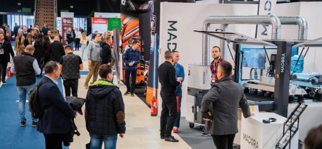 Busy aisle with machinery exhibitors in hall F